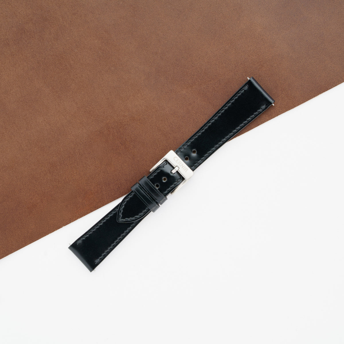 Black shell cordovan slim watch strap buckled with a steel pin buckle on brown leather
