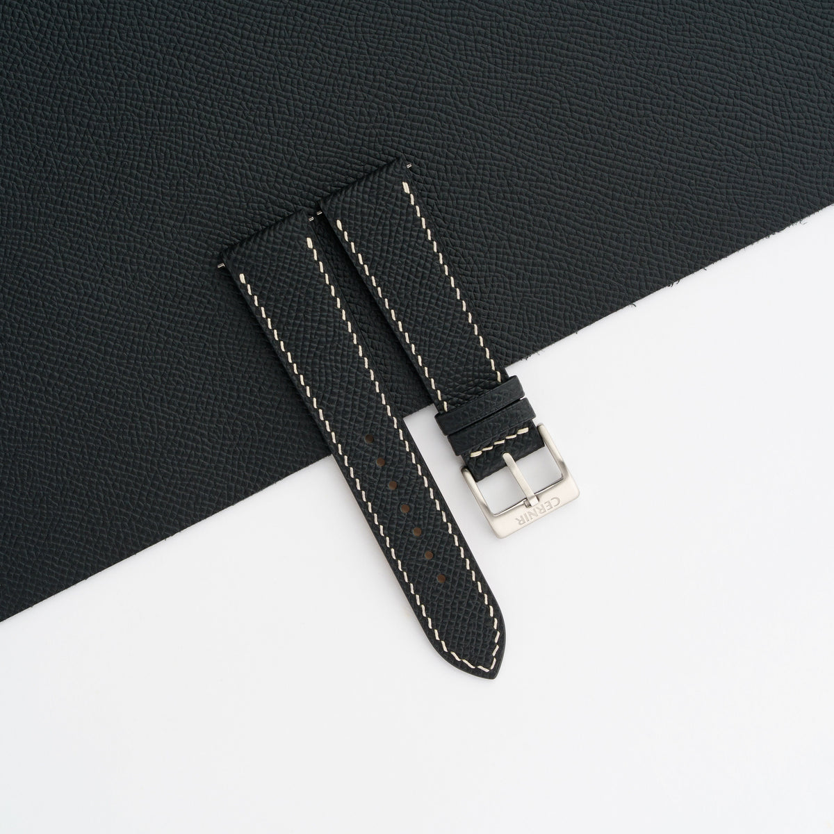 Black Epsom leather slim watch strap laid on a sheet of matching black leather