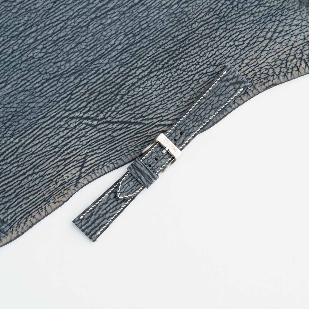 Grey blue shark slim watch strap buckled with a steel pin buckle, showing the ridged grain