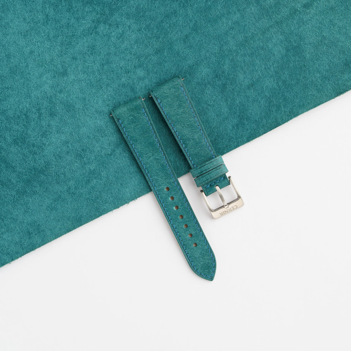 Turquoise Pueblo slim watch strap laid on a sheet of matching turquoise leather