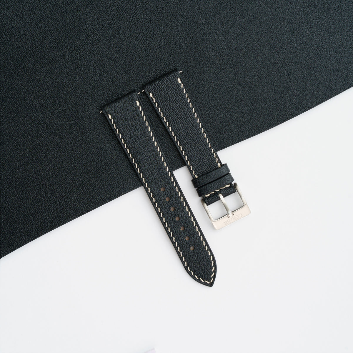 Black Alran Chevre Sully slim watch strap laid on a matching black goatskin sheet