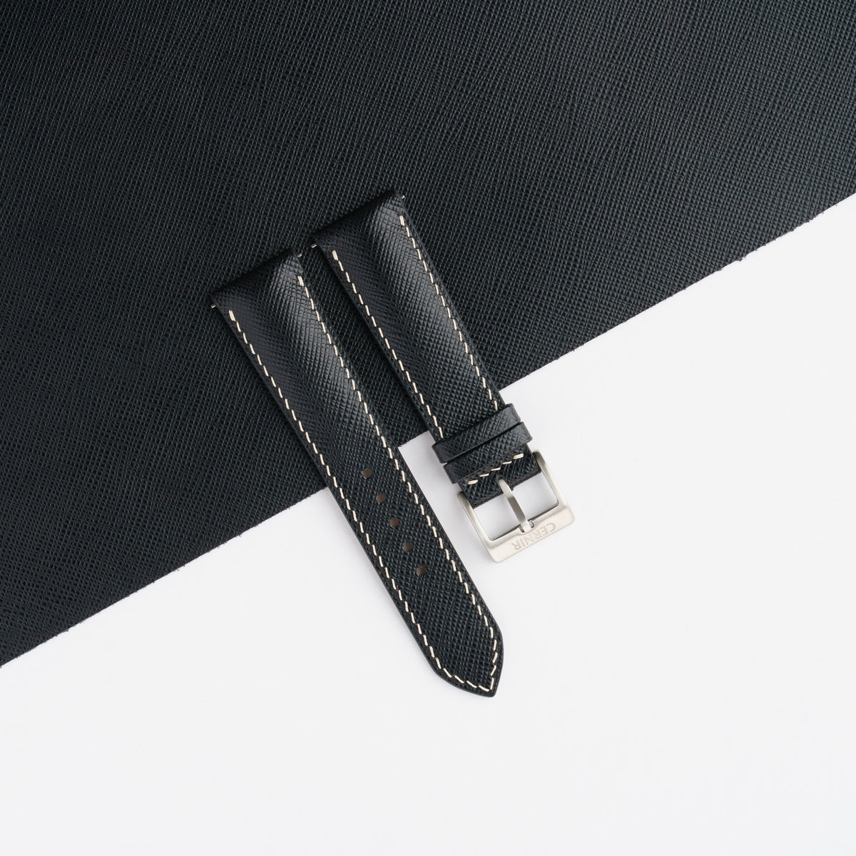 Black Saffiano padded watch strap laid on a sheet of matching black Saffiano leather