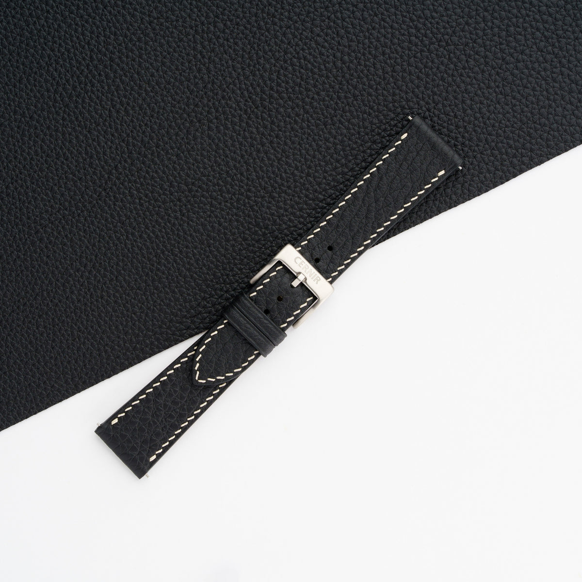 Buckled black Togo slim watch strap with cream stitching, showing the pebbled grain