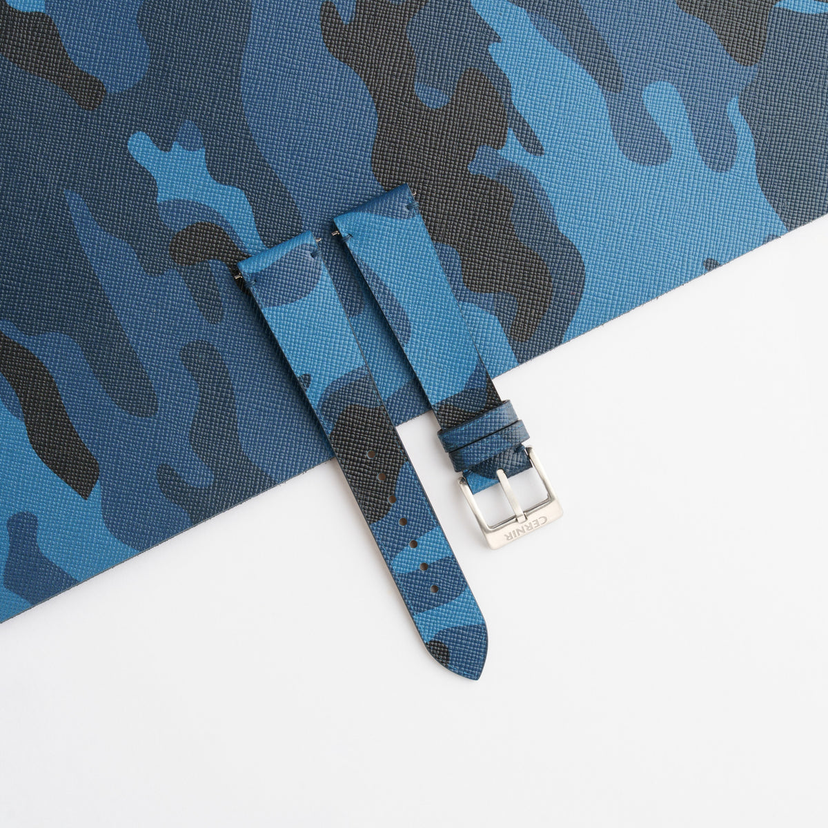 Blue Camo Saffiano side-stitch watch strap laid on a sheet of matching camouflage leather