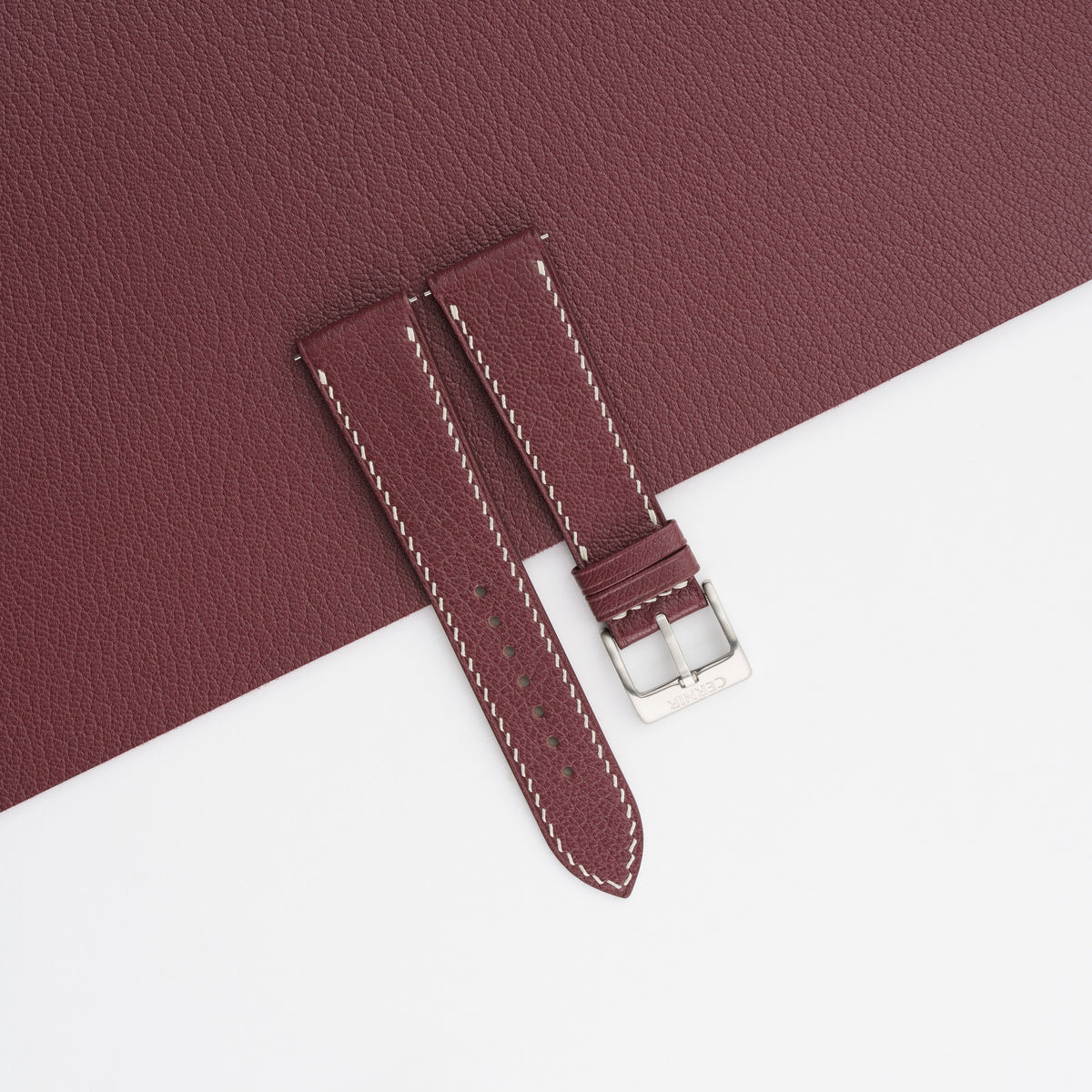Bordeaux Alran Chevre Sully slim watch strap laid on a matching bordeaux goatskin sheet