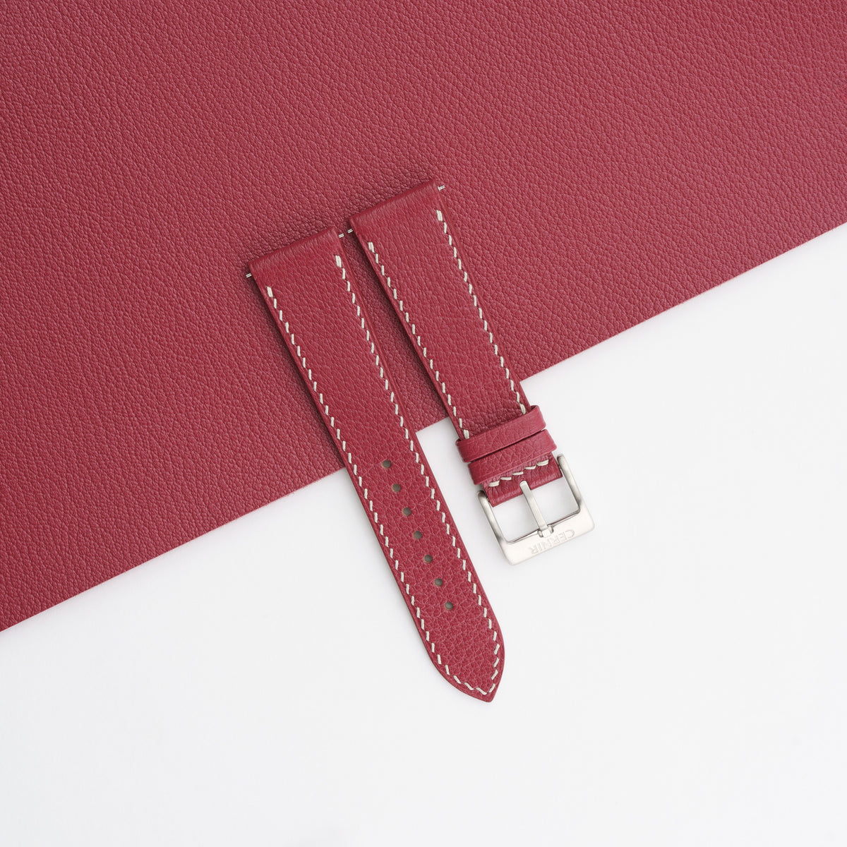 Burgundy Alran Chevre Sully slim watch strap laid on a matching burgundy goatskin sheet