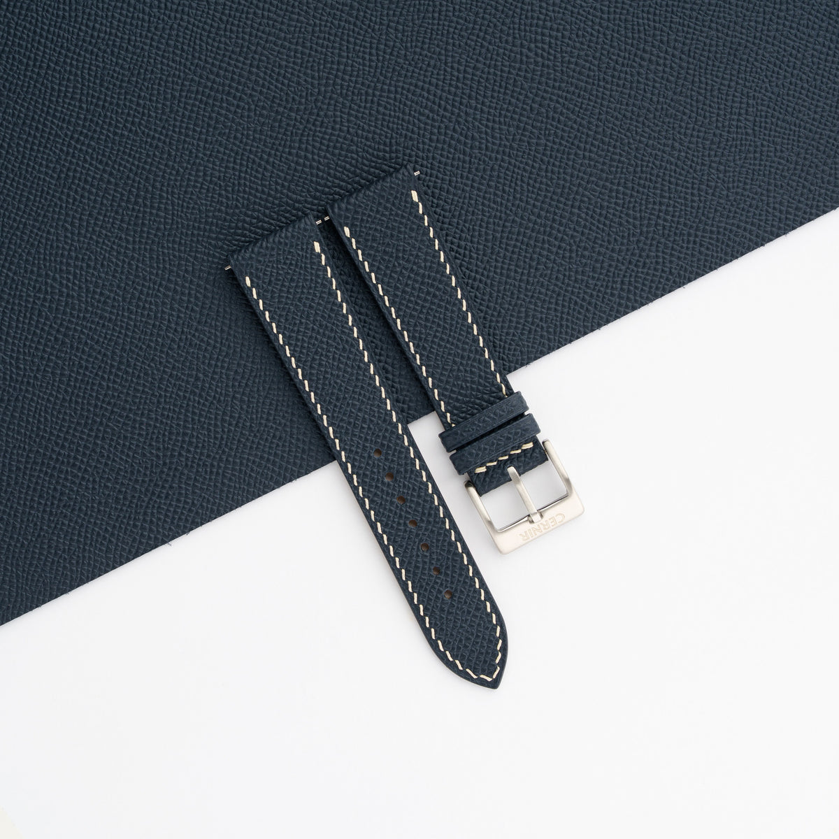 Dark navy Epsom slim watch strap laid on a sheet of matching dark navy Epsom leather