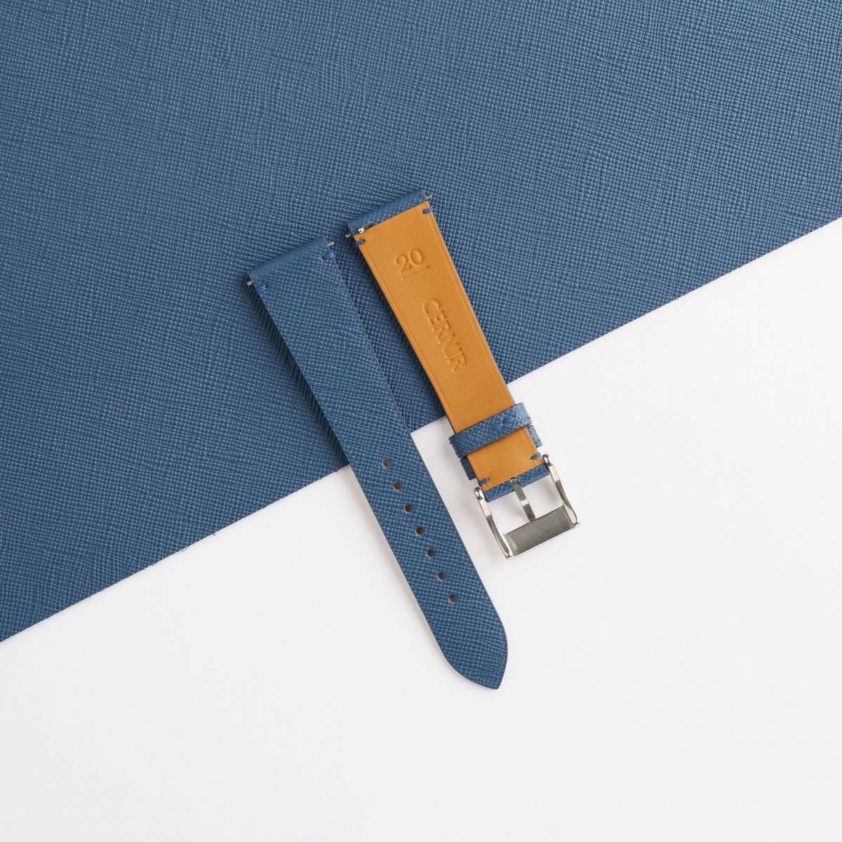 Golden tan Zermatt leather lining on the back of the denim blue Saffiano side-stitch strap