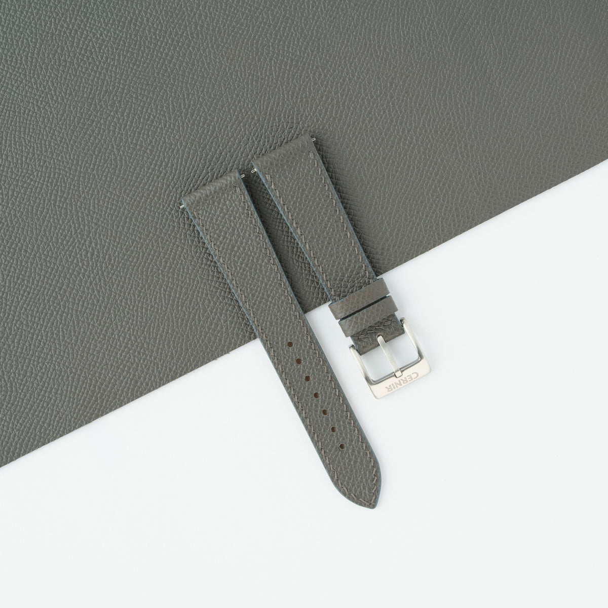 Grey Epsom slim watch strap laid on a sheet of matching grey Epsom leather