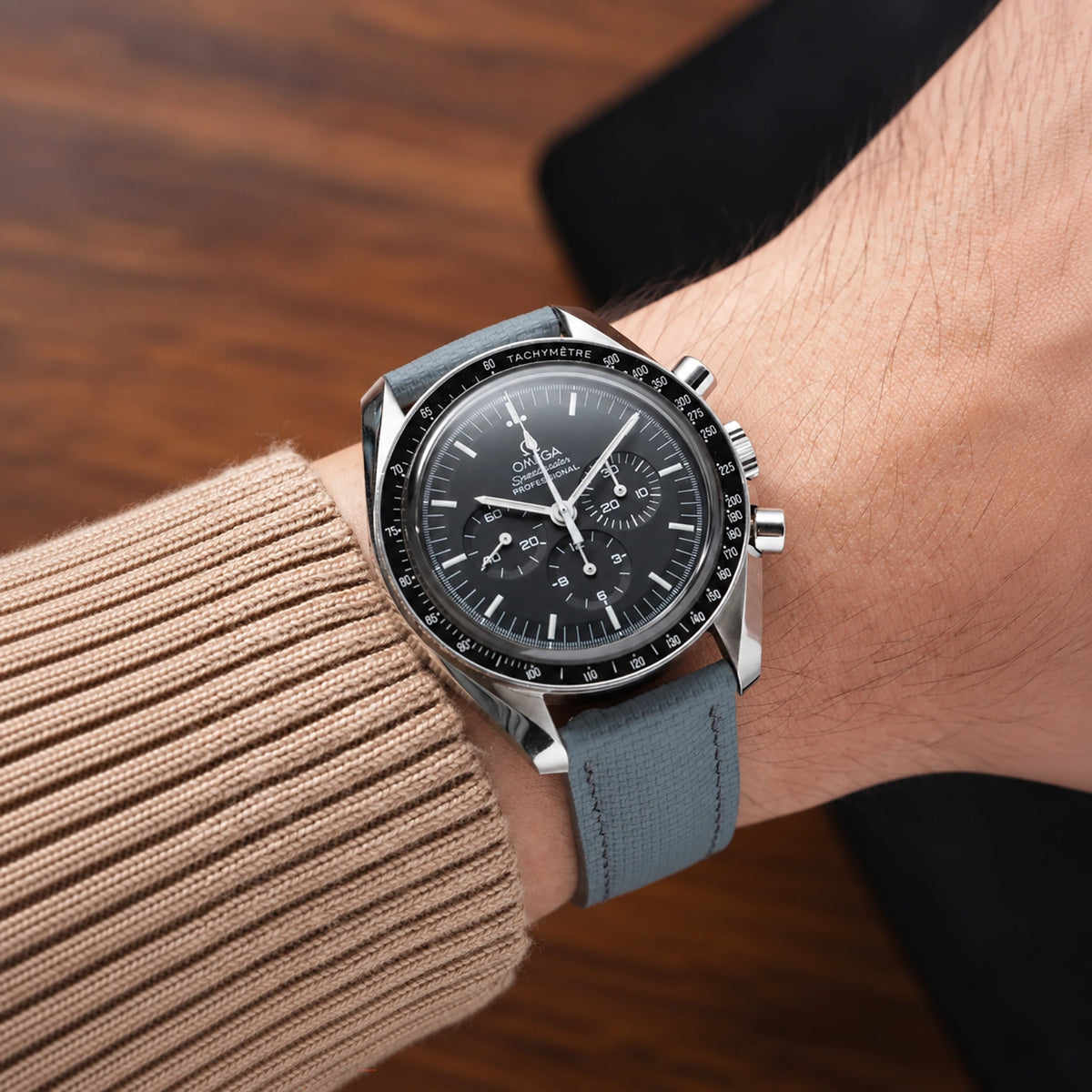 Grey sailcloth padded watch strap fitted to an Omega Speedmaster Professional with a black dial