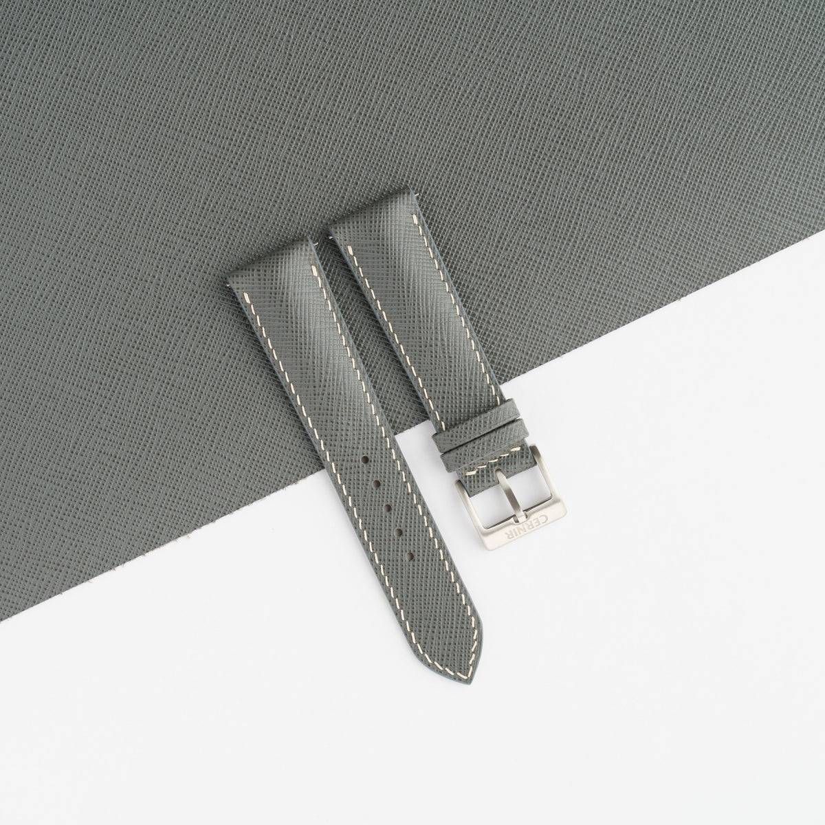 Grey Saffiano padded watch strap laid on a sheet of matching grey Saffiano leather