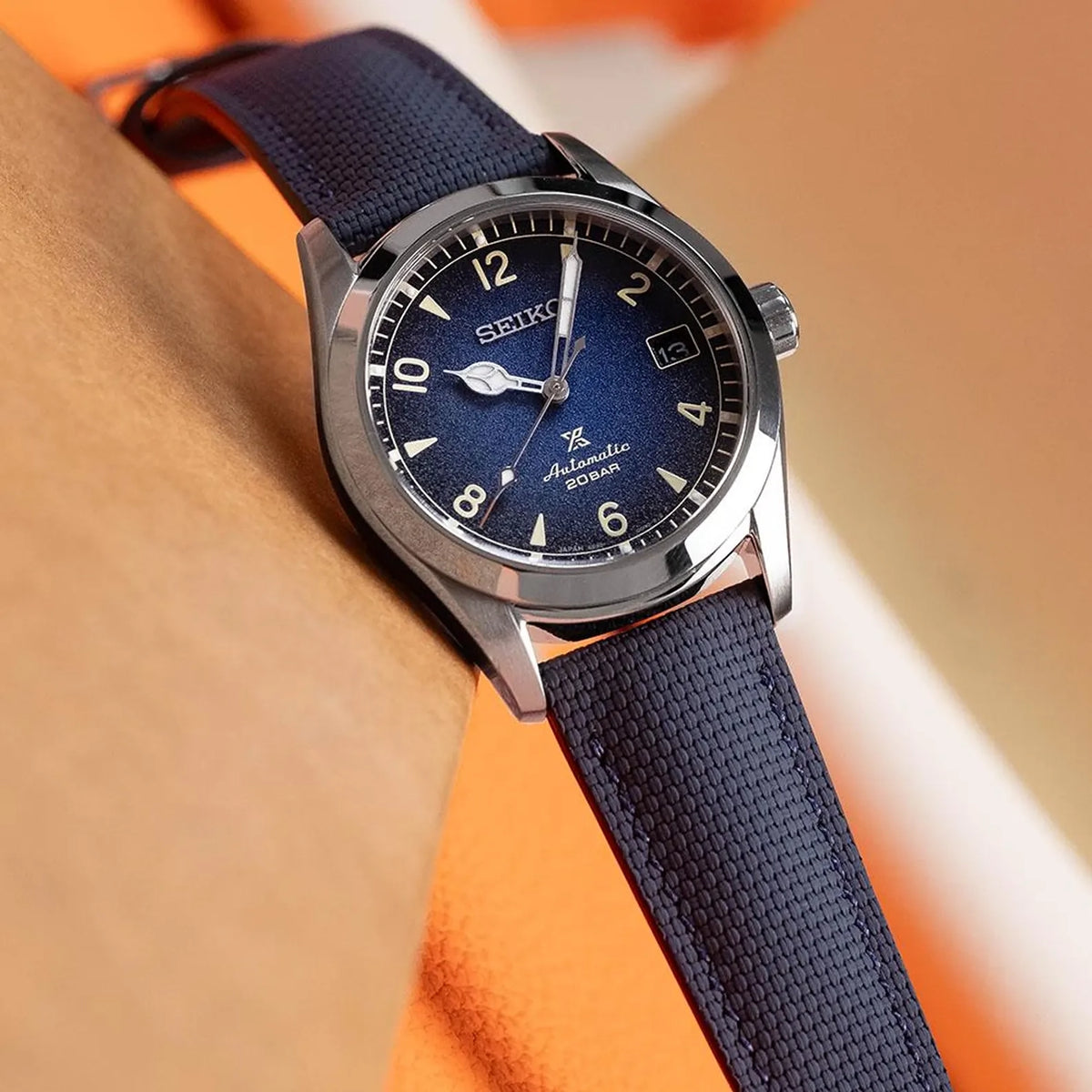 Navy sailcloth padded watch strap fitted to a Seiko automatic with a blue gradient dial