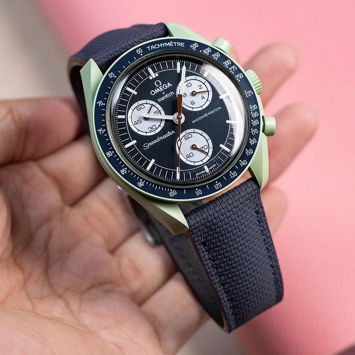 Navy sailcloth padded watch strap on an Omega x Swatch MoonSwatch with a green case