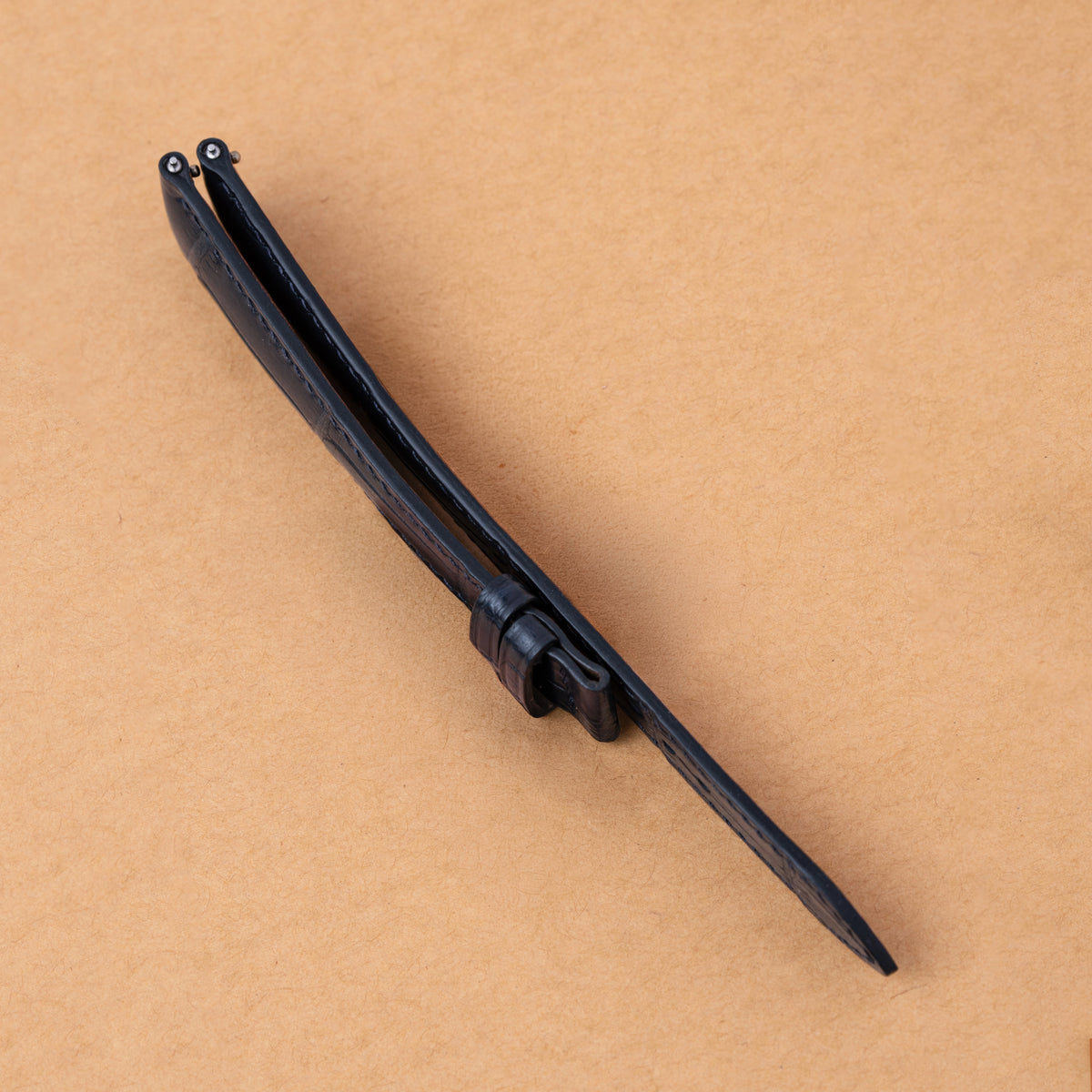 Side view of the navy alligator padded strap showing its raised profile and taper
