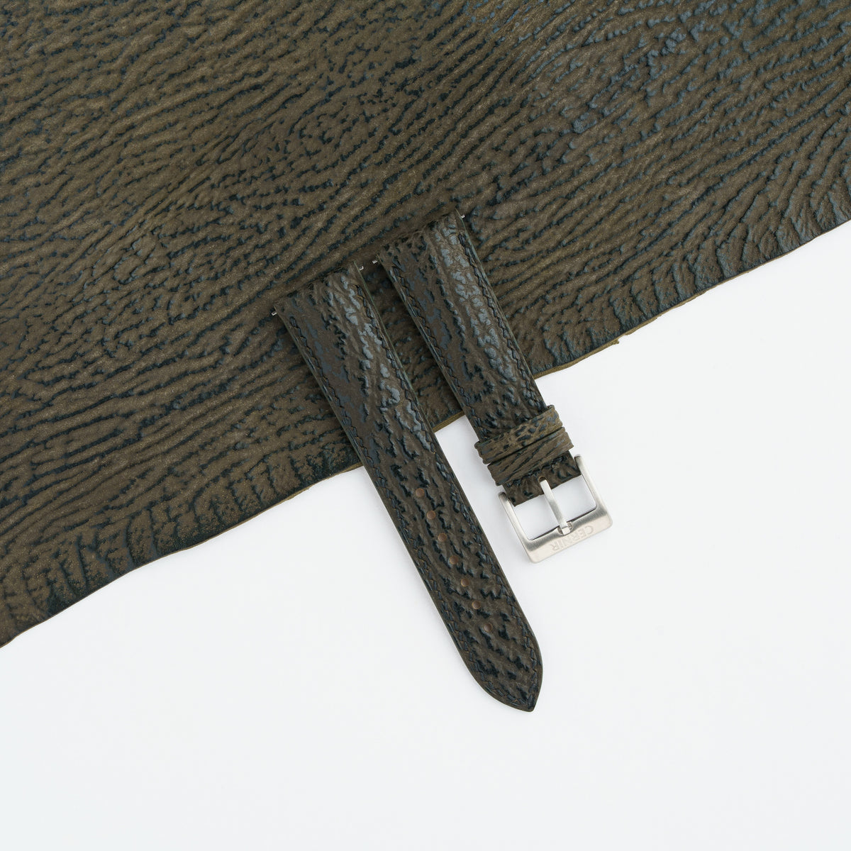 Olive brown shark padded watch strap laid on a sheet of matching olive brown shark leather