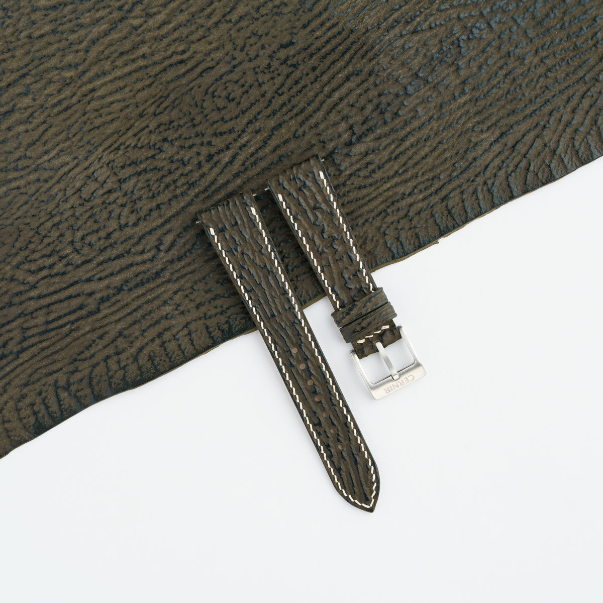 Olive brown shark slim watch strap laid on a sheet of matching olive brown shark leather