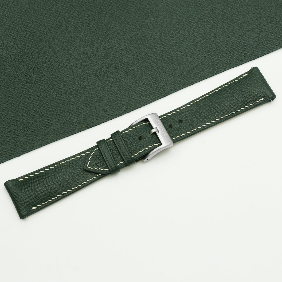 Buckled olive green Epsom padded watch strap laid on matching green Epsom leather