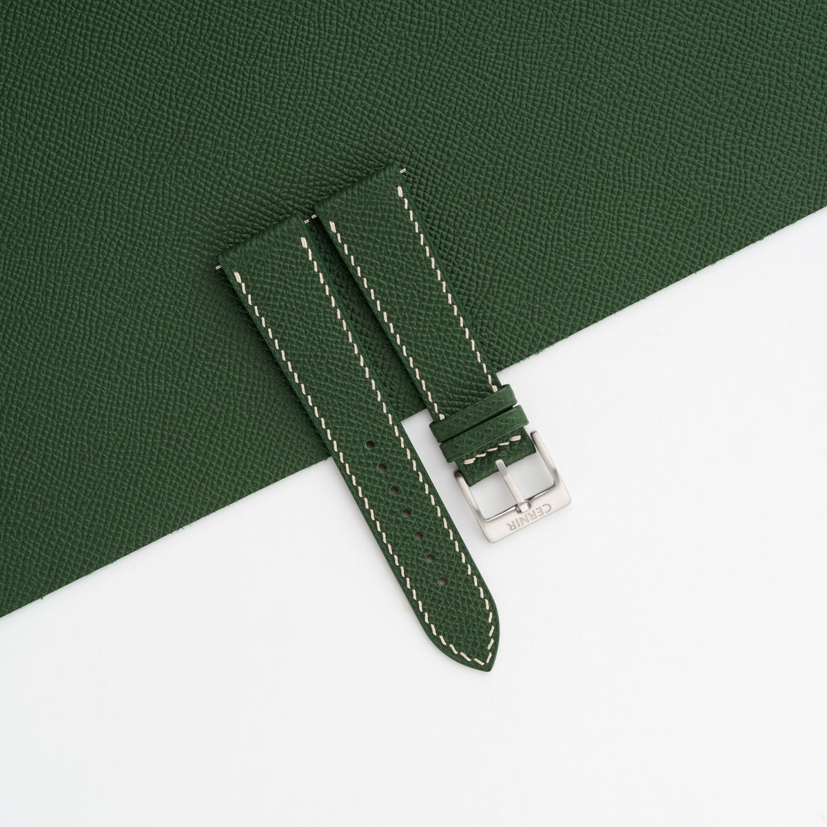 Forest green Epsom slim watch strap laid on a sheet of matching forest green Epsom leather