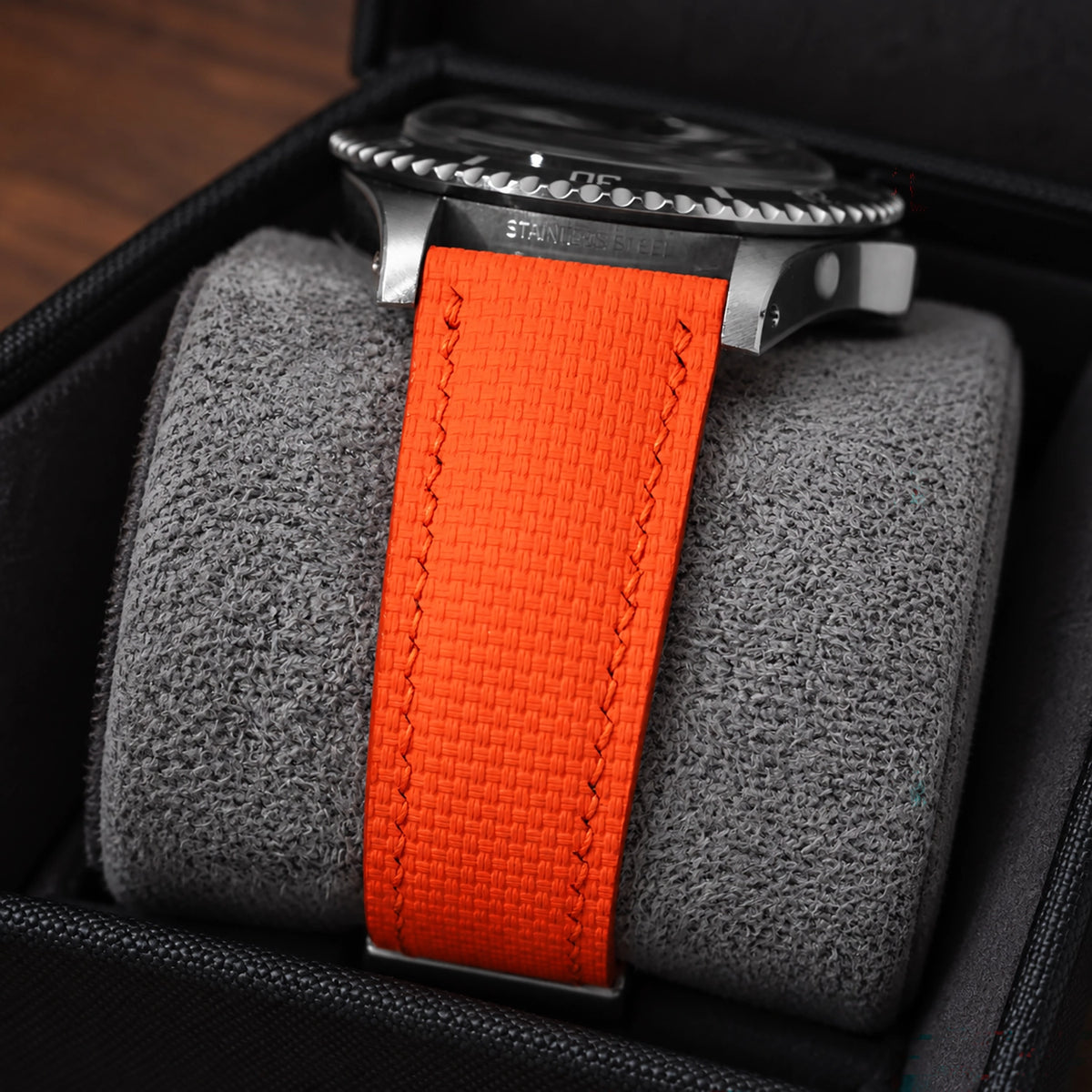 Close-up of the orange rubber sailcloth padded strap on a steel diver in a watch box