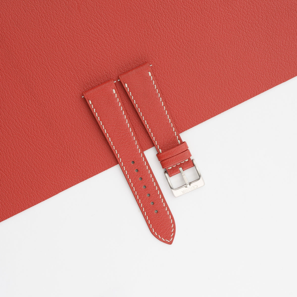 Red Alran Chevre Sully slim watch strap laid on a matching red goatskin sheet