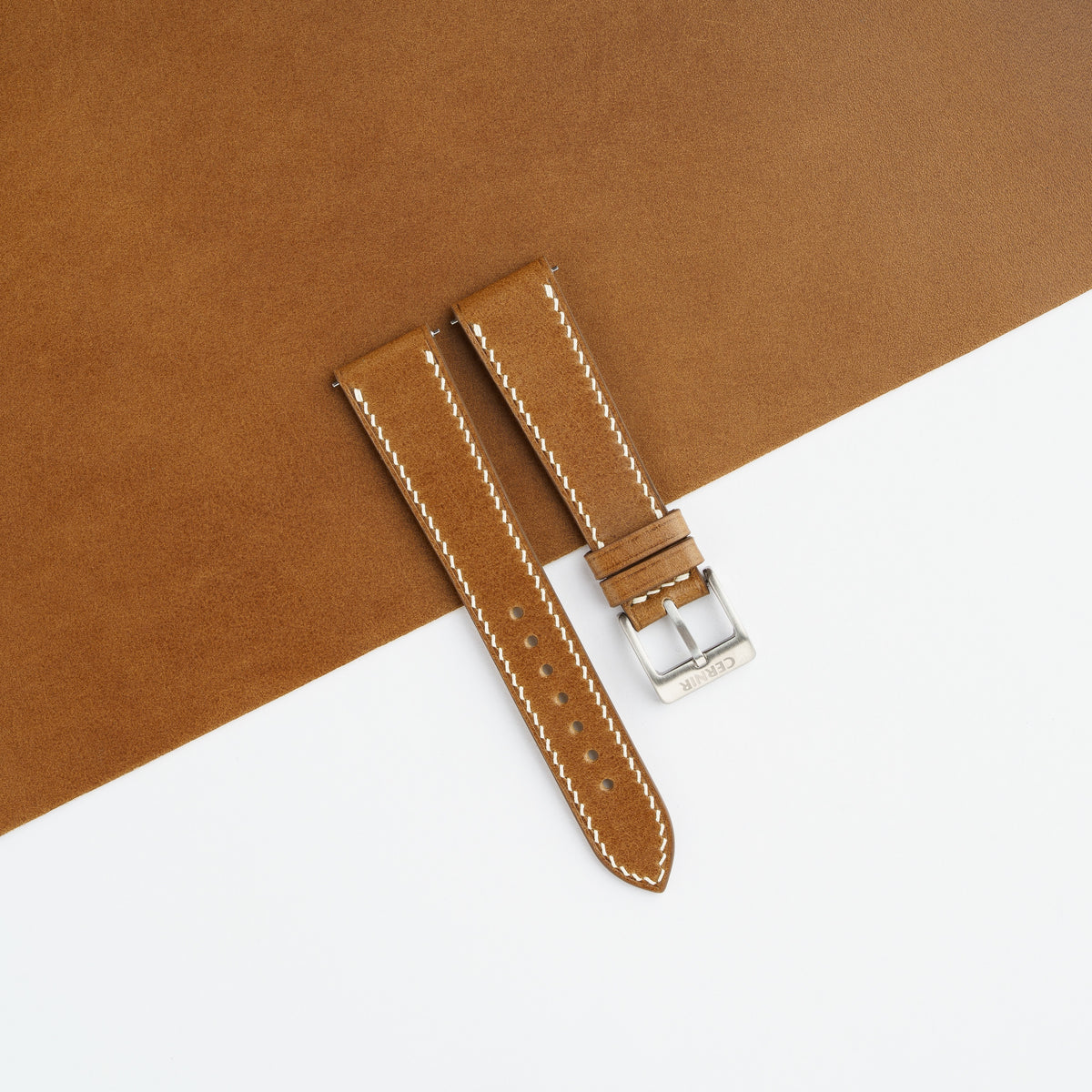 Tan Buttero slim watch strap laid on a sheet of matching tan leather