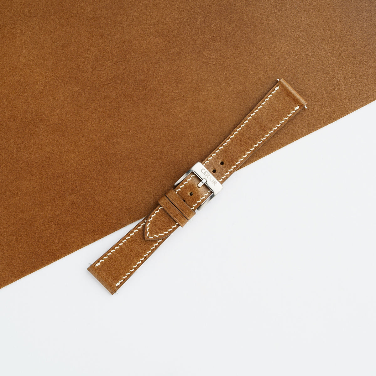 Tan Buttero slim watch strap buckled with a steel pin buckle, with cream edge stitching