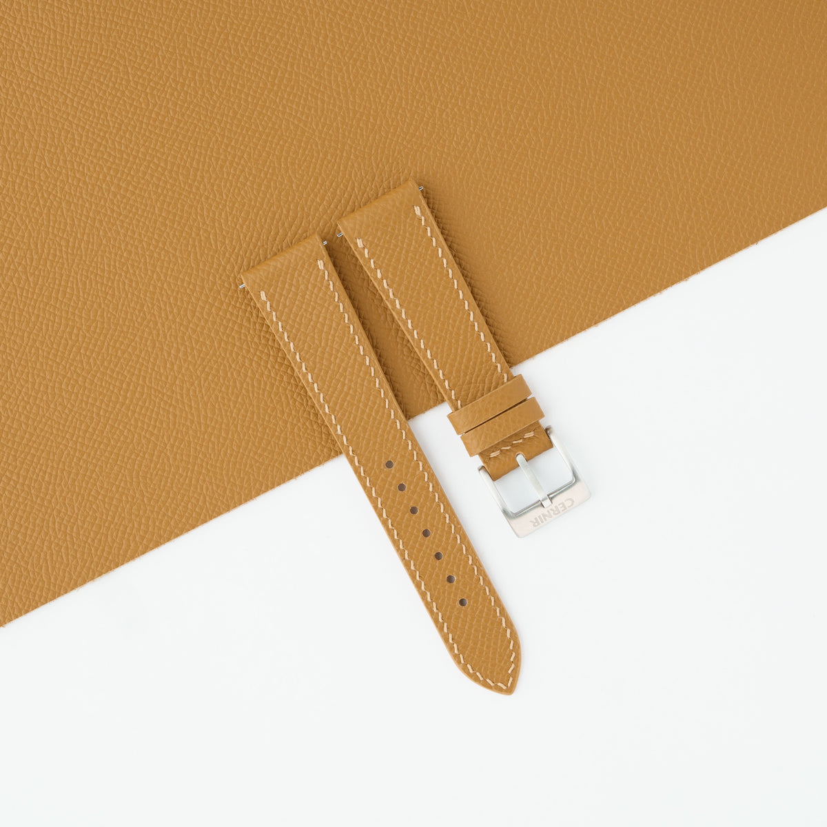 Tan Epsom slim watch strap laid on a sheet of matching tan Epsom leather