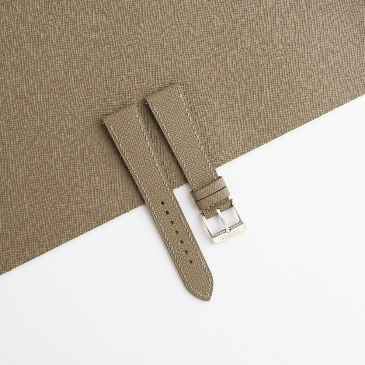 Taupe Saffiano slim watch strap laid on a sheet of matching taupe Saffiano leather