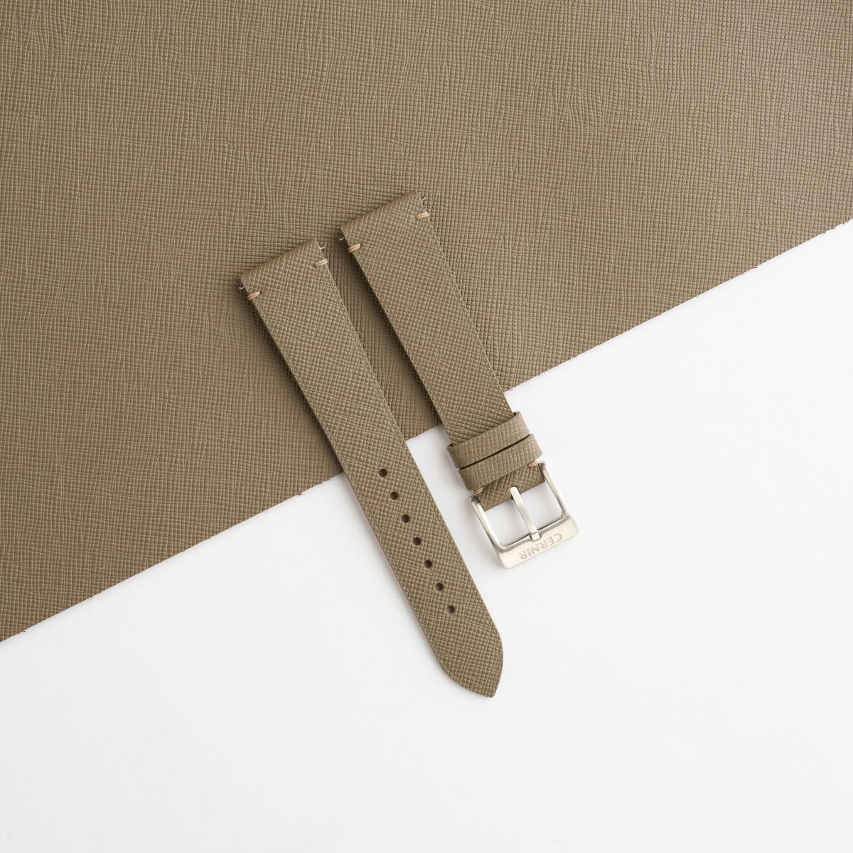 Taupe Saffiano side-stitch watch strap laid on a sheet of matching taupe leather