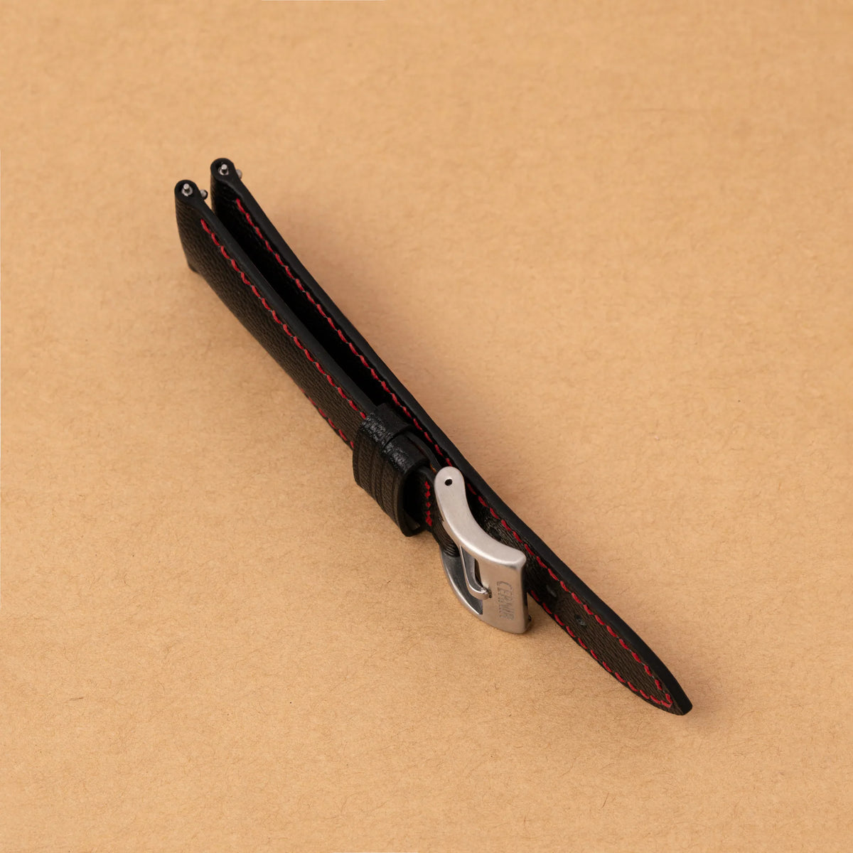 Side view of the black Alran Chevre Sully padded strap, showing its raised, cushioned profile