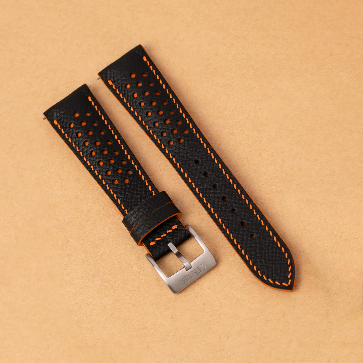 Black Epsom Racing Rally padded strap with orange stitching and a steel pin buckle on kraft paper