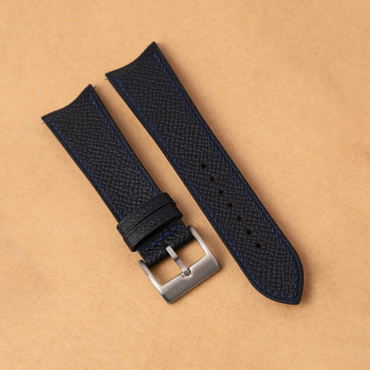 Black Epsom leather slim watch strap with a curved end, navy stitching and a steel pin buckle