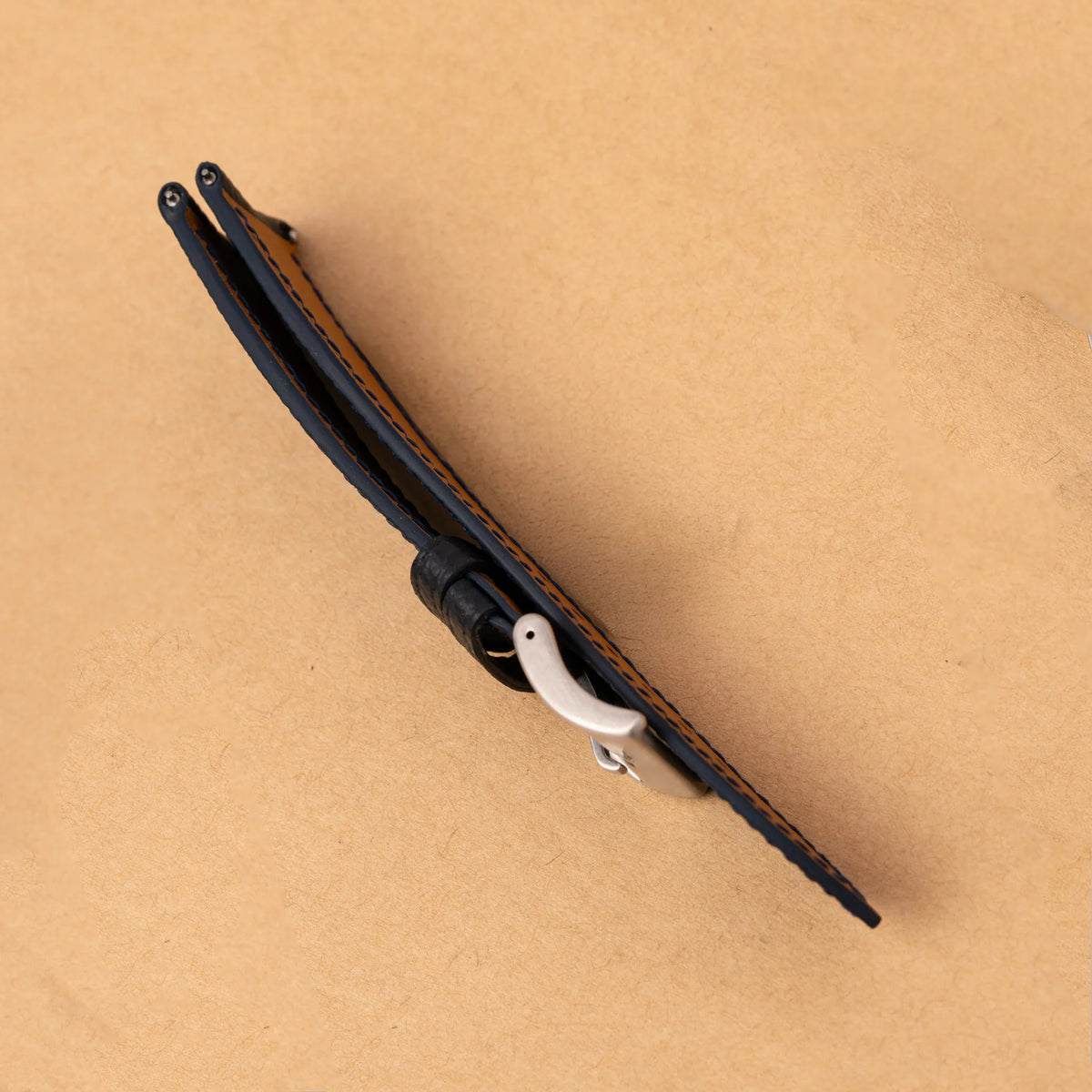 Side view of the black Epsom slim curved end strap, showing its thin profile and dark painted edge