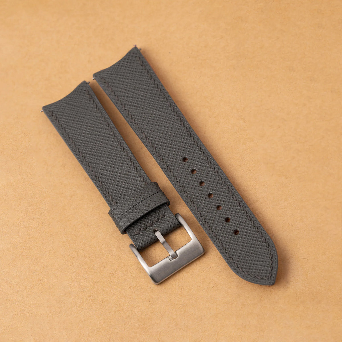 Grey Saffiano leather slim watch strap with a curved end, matching grey stitching and a steel pin buckle