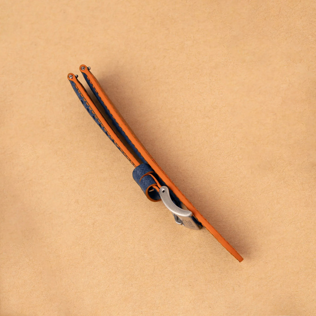 Side view of the padded navy Epsom Racing Rally strap, showing its orange painted edges