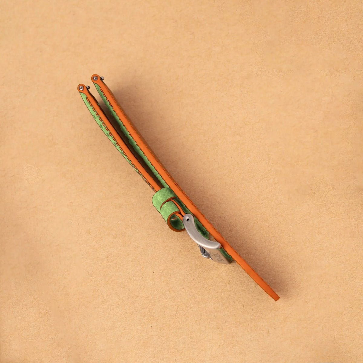 Side view of the padded pistachio green Epsom Racing Rally strap, showing its orange painted edges