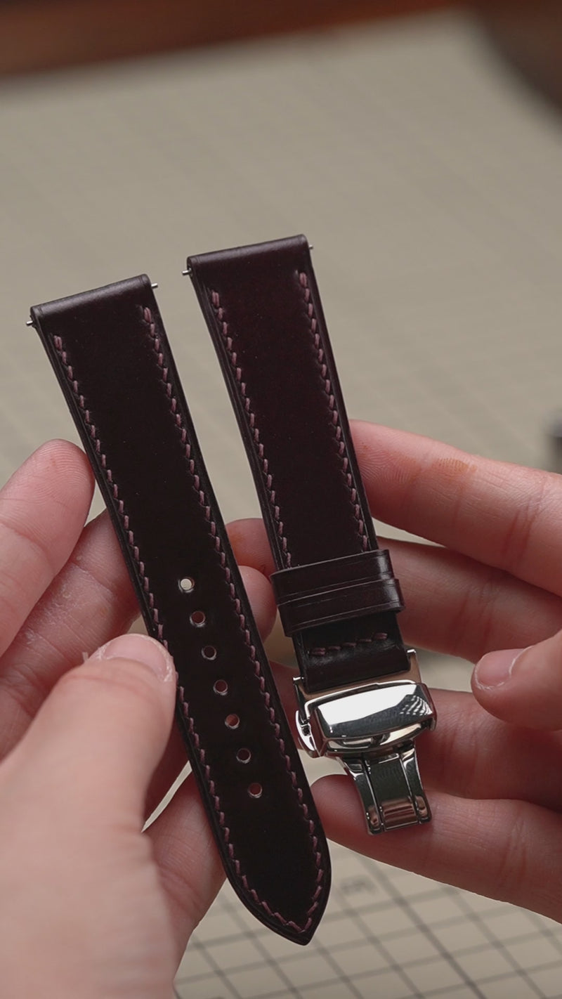 Video: Burgundy Shell Cordovan Leather Slim Watch Strap with a folding clasp, held in both hands