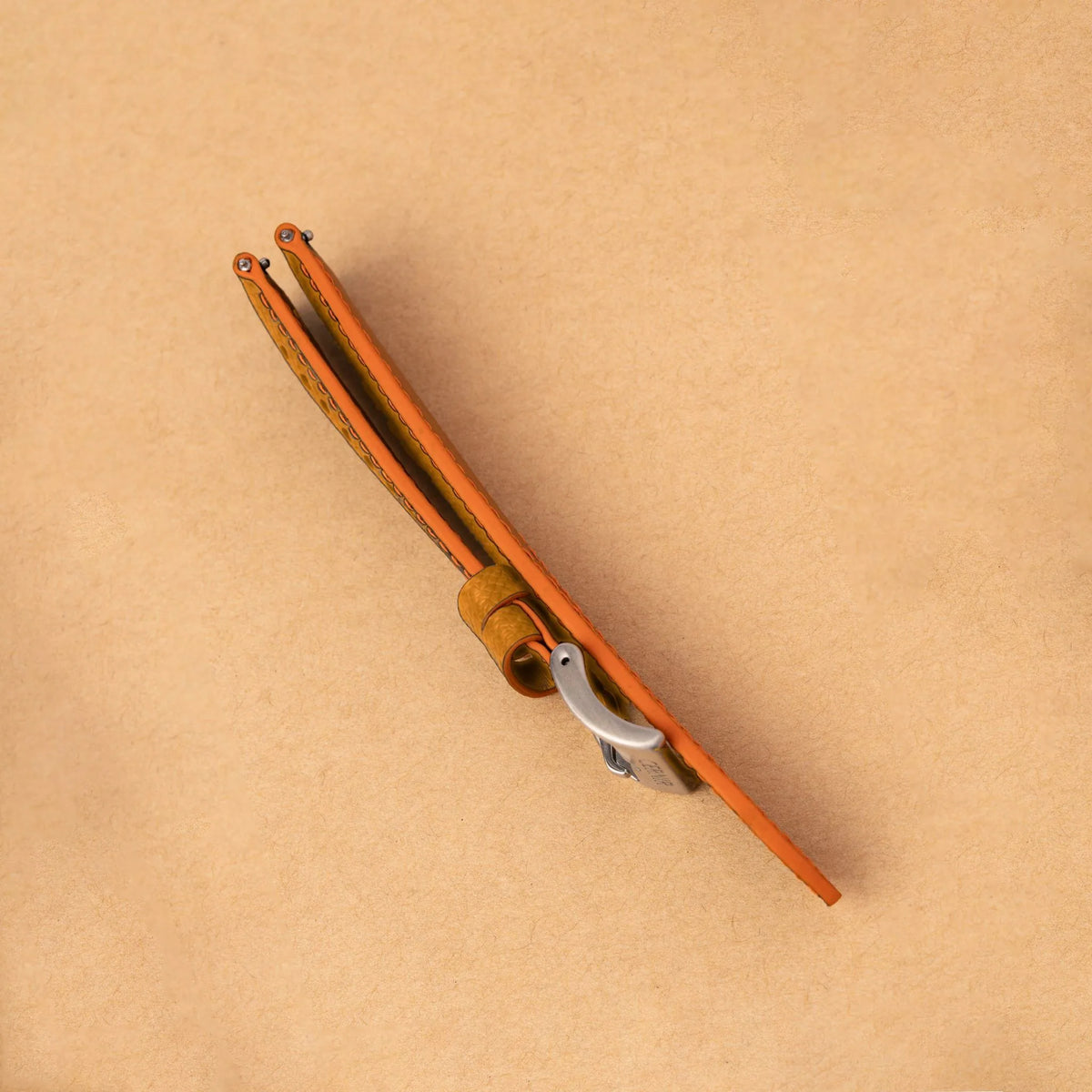 Side view of the padded tan Epsom Racing Rally strap, showing its orange painted edges